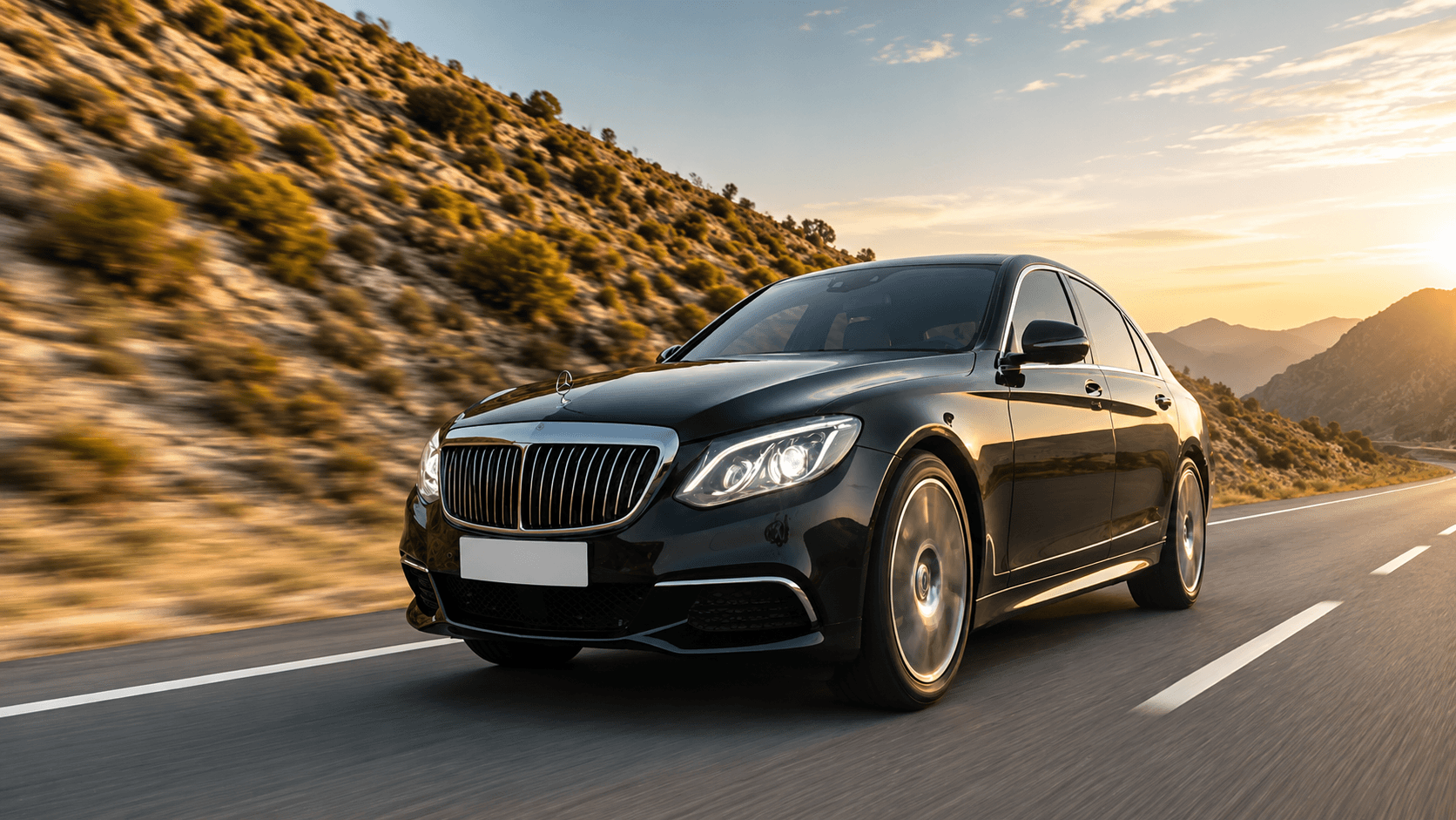Luxury Mercedes sedan driving on a mountain highway at dusk